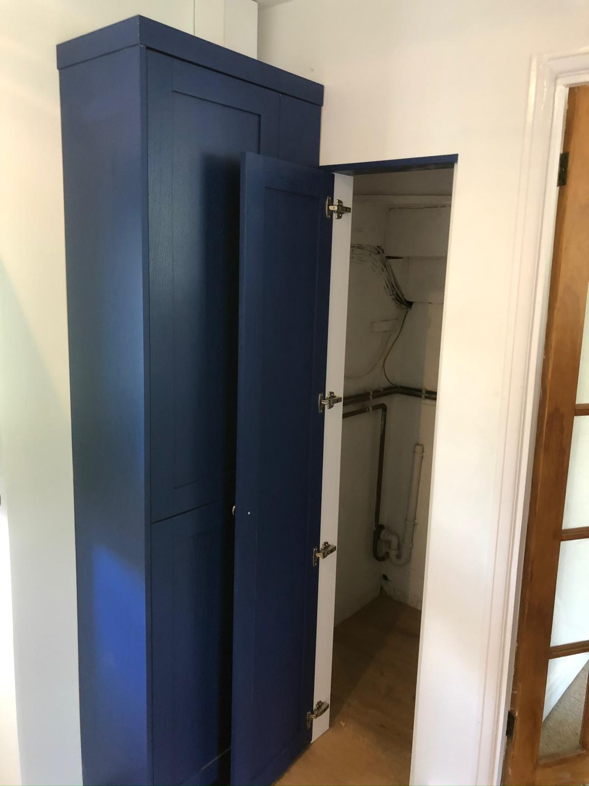 Blue painted boiler cupboard with panelled doors
