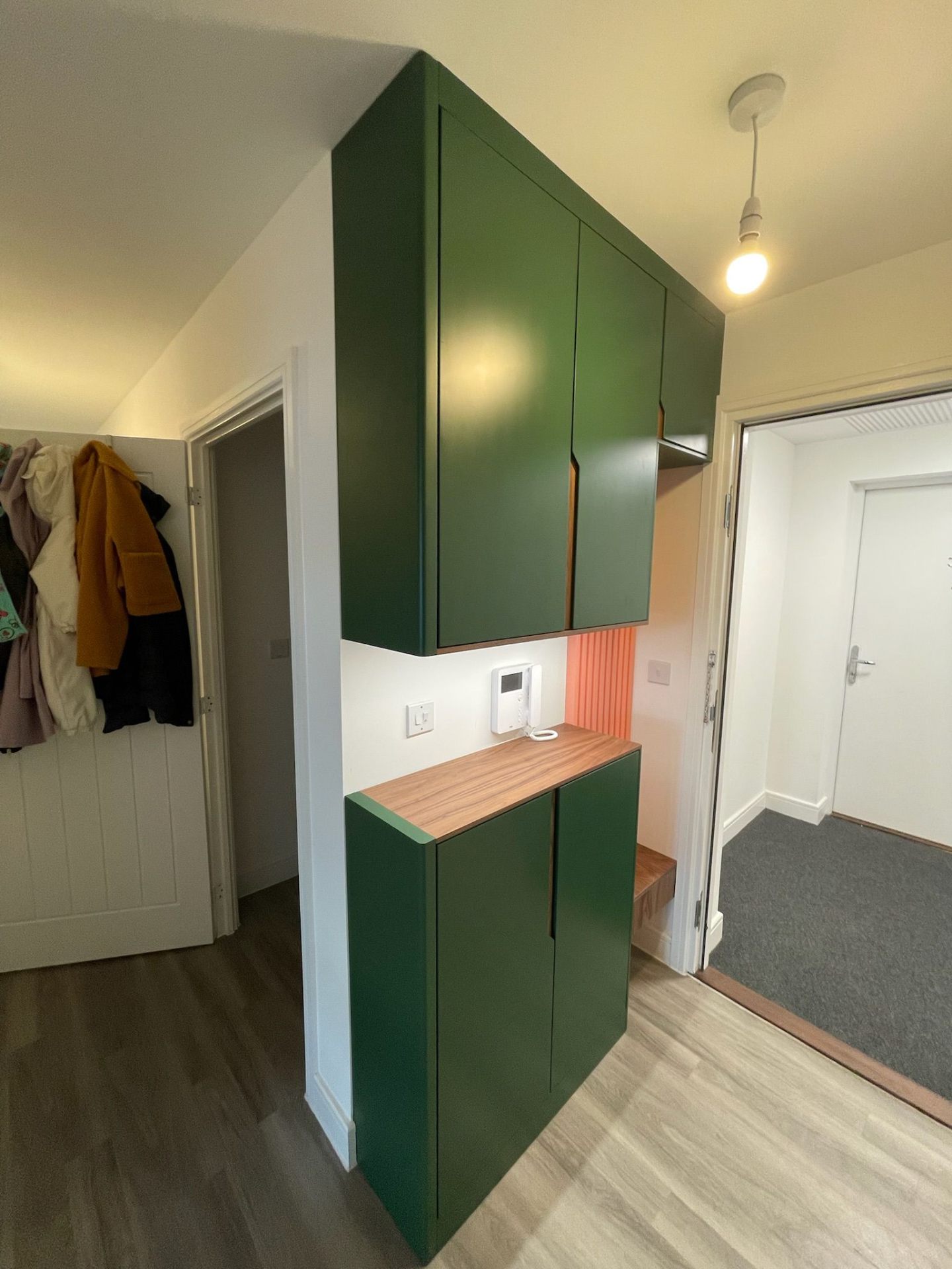 Green hallway storage cabinet with hooks and shoe drawers