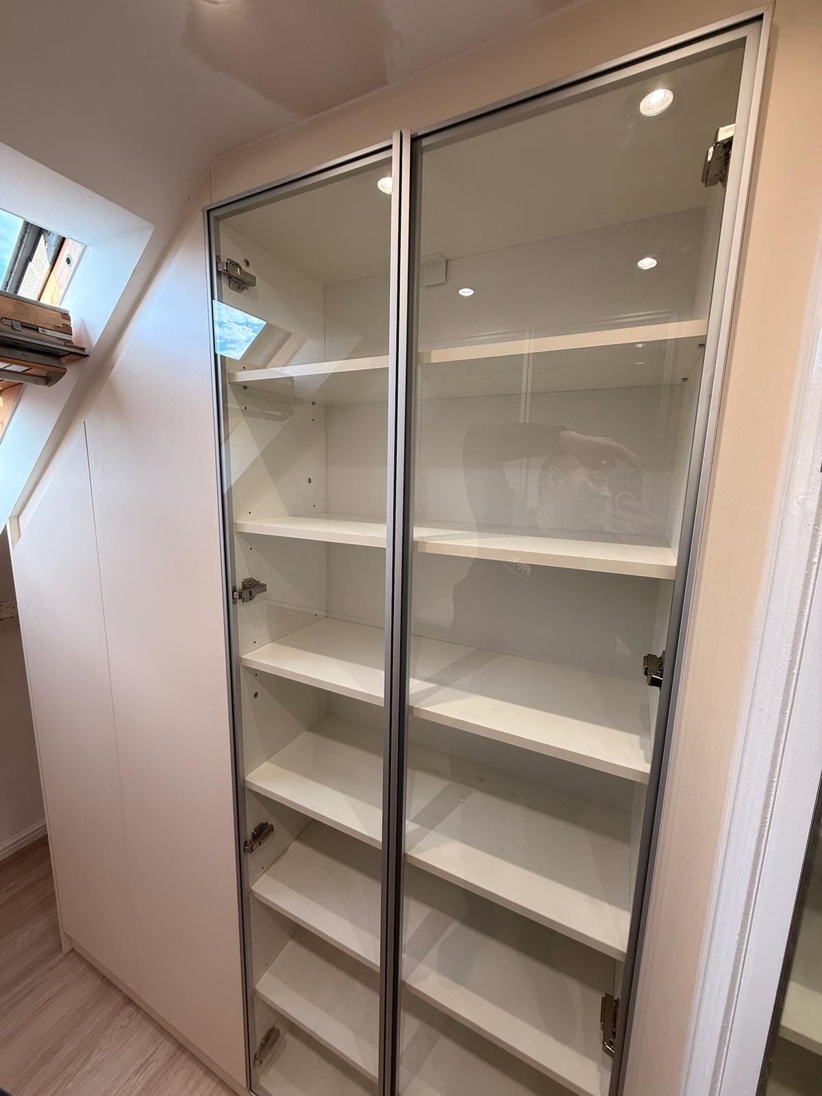 Glass-fronted display shelving built into a loft conversion