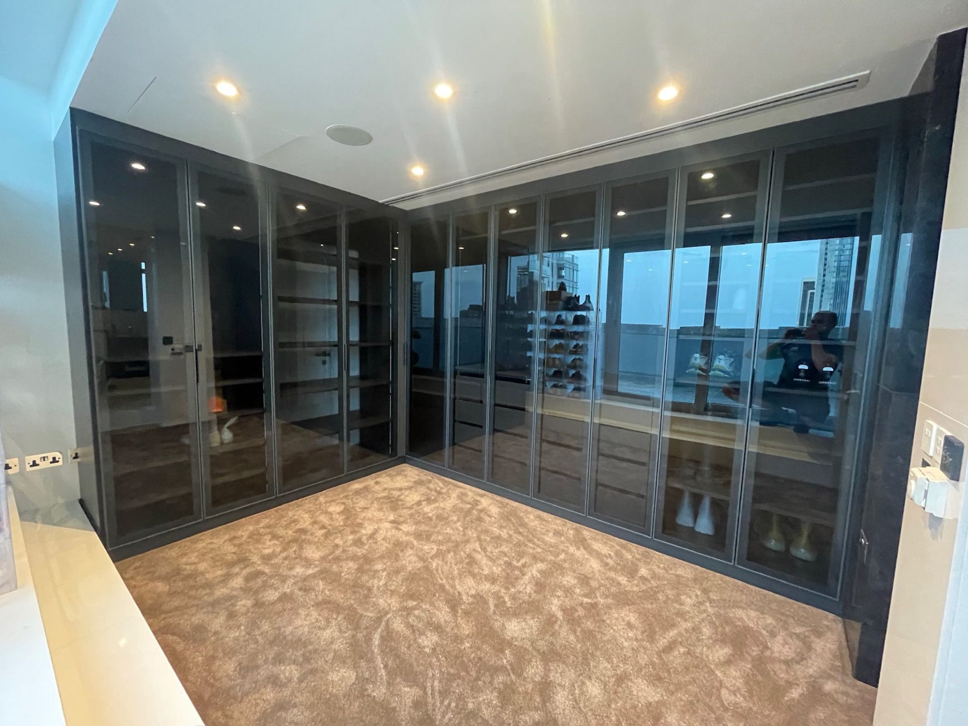 Walk-in wardrobe with glass doors flooded with natural daylight