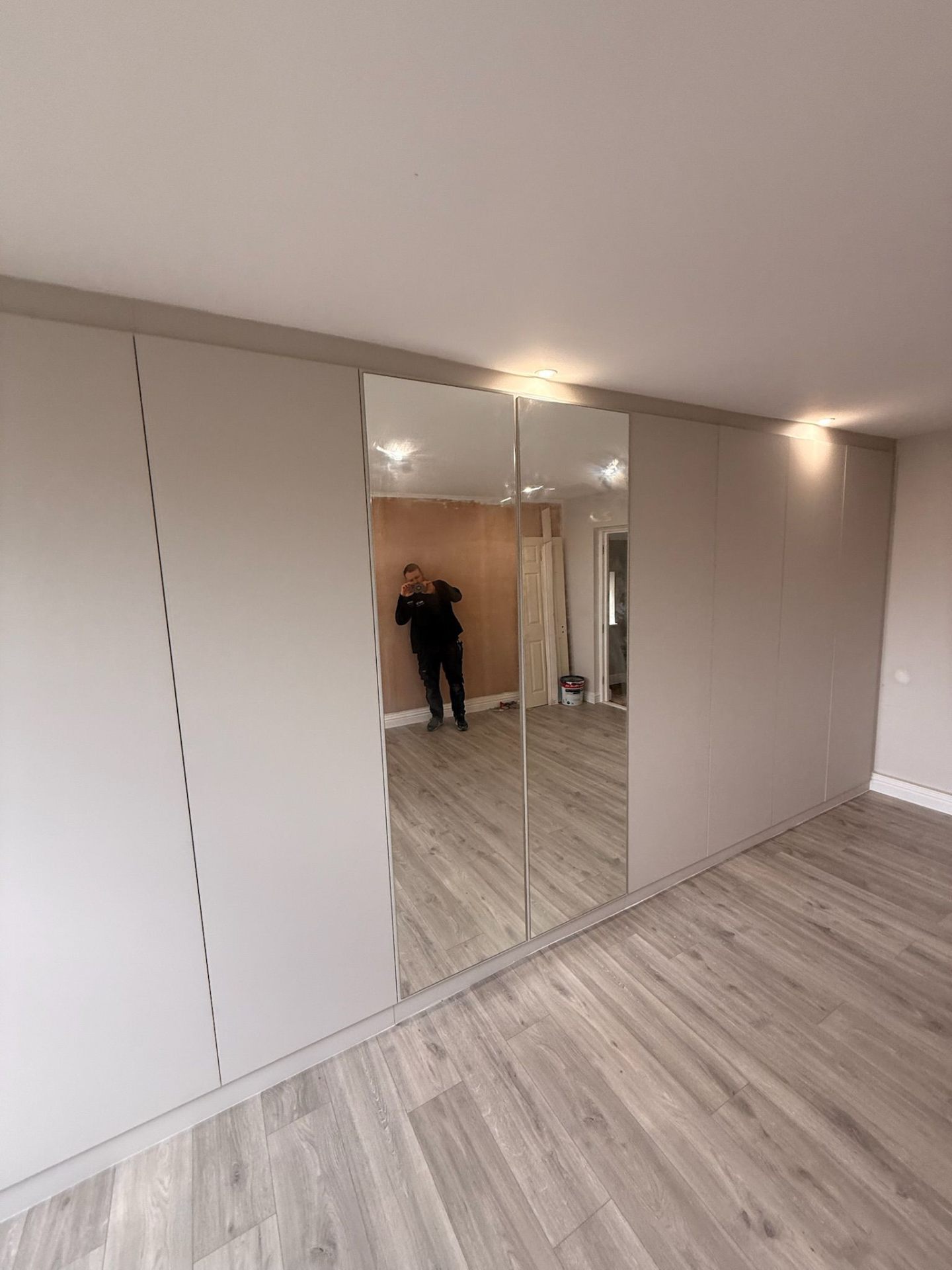 Close-up of fitted wardrobe mirror door with seamless edge detail
