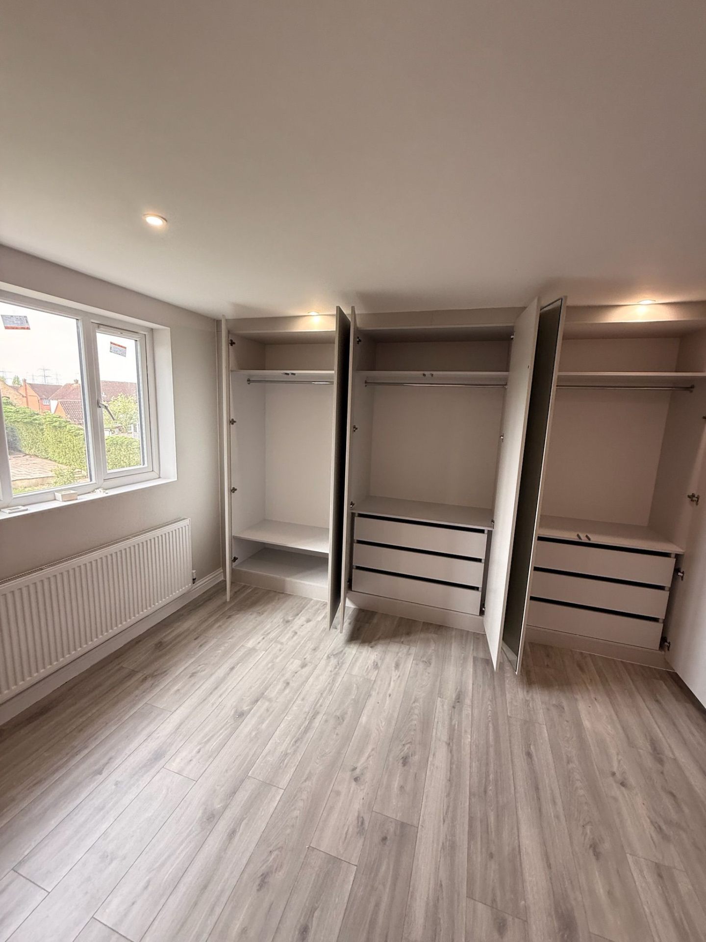 Fitted wardrobe with open doors showing soft-close drawer system