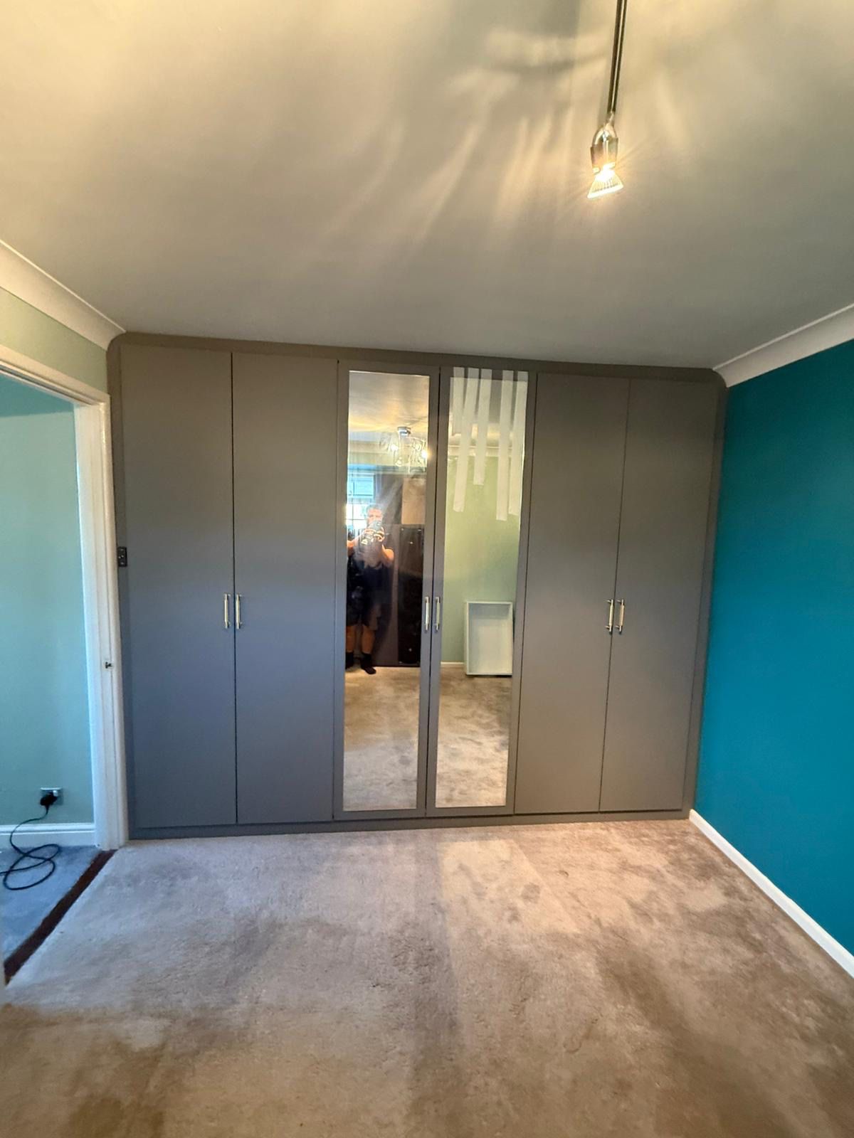 Grey fitted wardrobe with integrated mirror doors