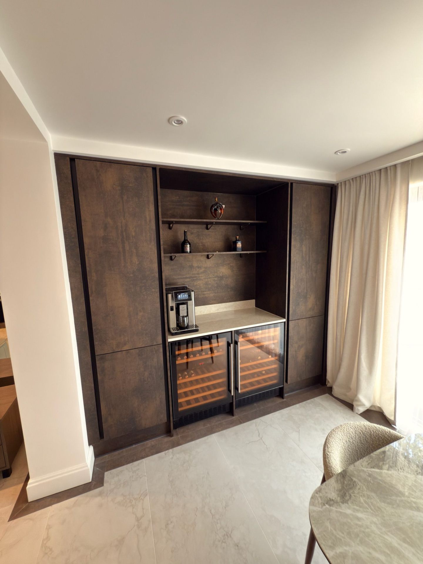 Built-in wine bar with LED-lit glass shelves and drawers